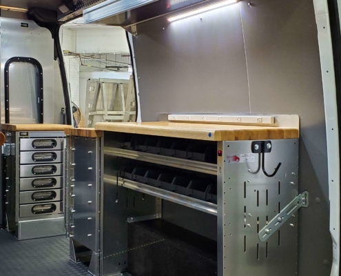 A van upfit with a work space counter and drawers