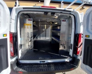 Back doors open in white van with shelving